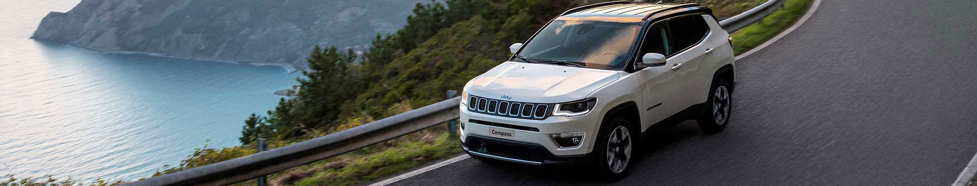 vit jeep kör på landsväg
