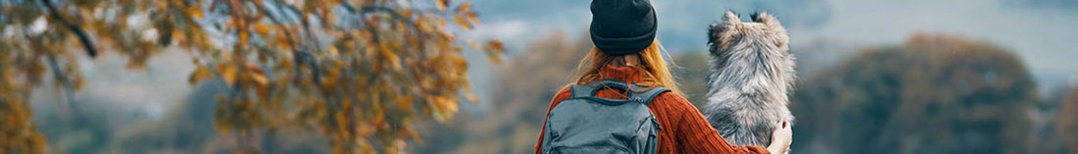 ung kvinna sitter tillsammans med sin hund i naturen