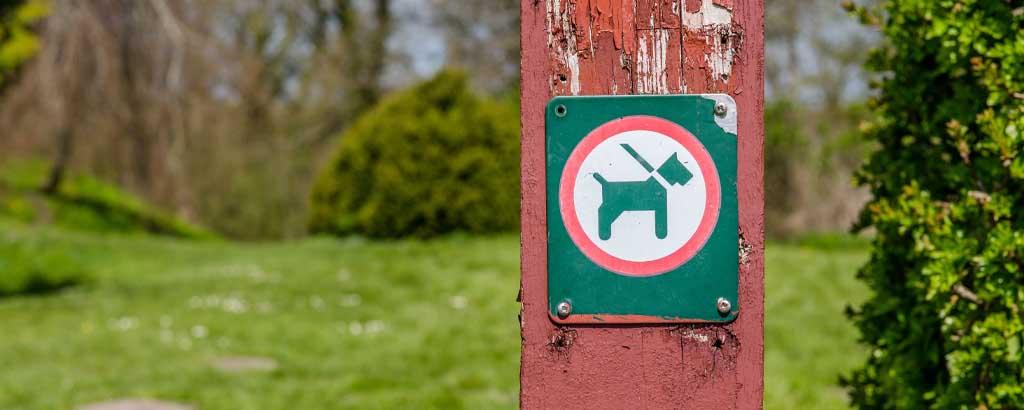 En skylt som visar koppeltvång för hund