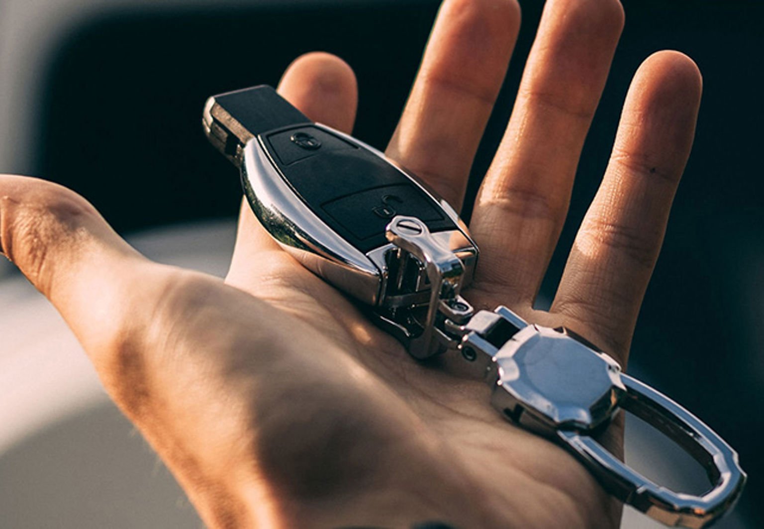 man håller bilnyckel i handen