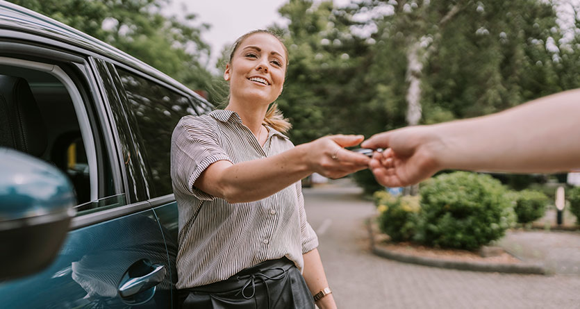 kvinna tar emot sina bilnycklar