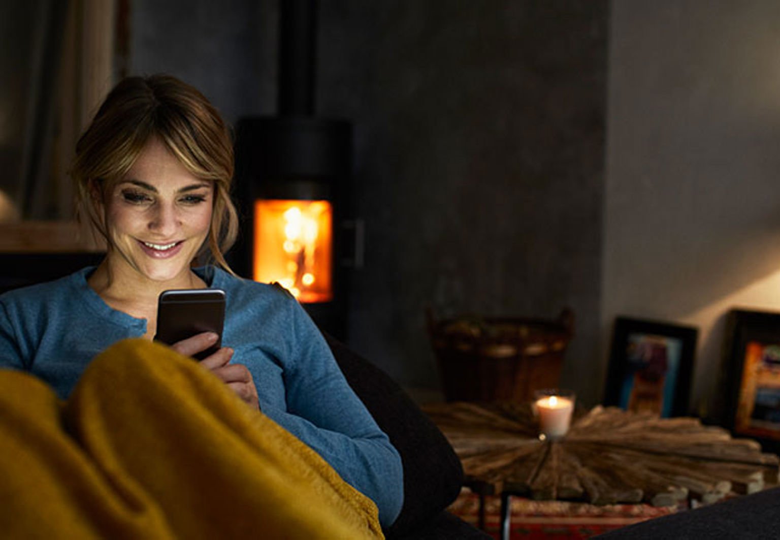 kvinna sitter i fåtölj framför kaminen