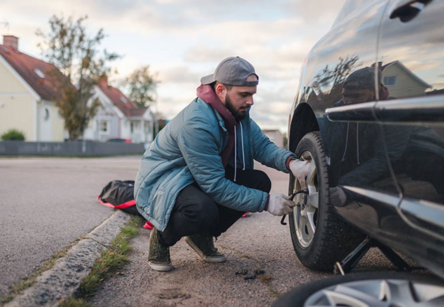 man byter däck på sin bil