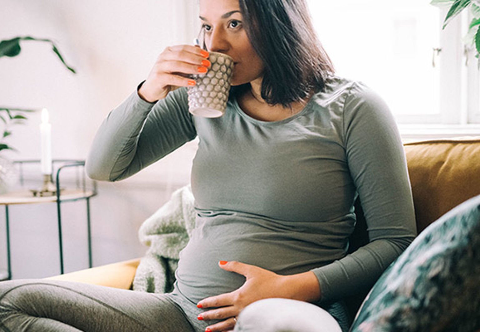 gravid kvinna dricker en kopp te