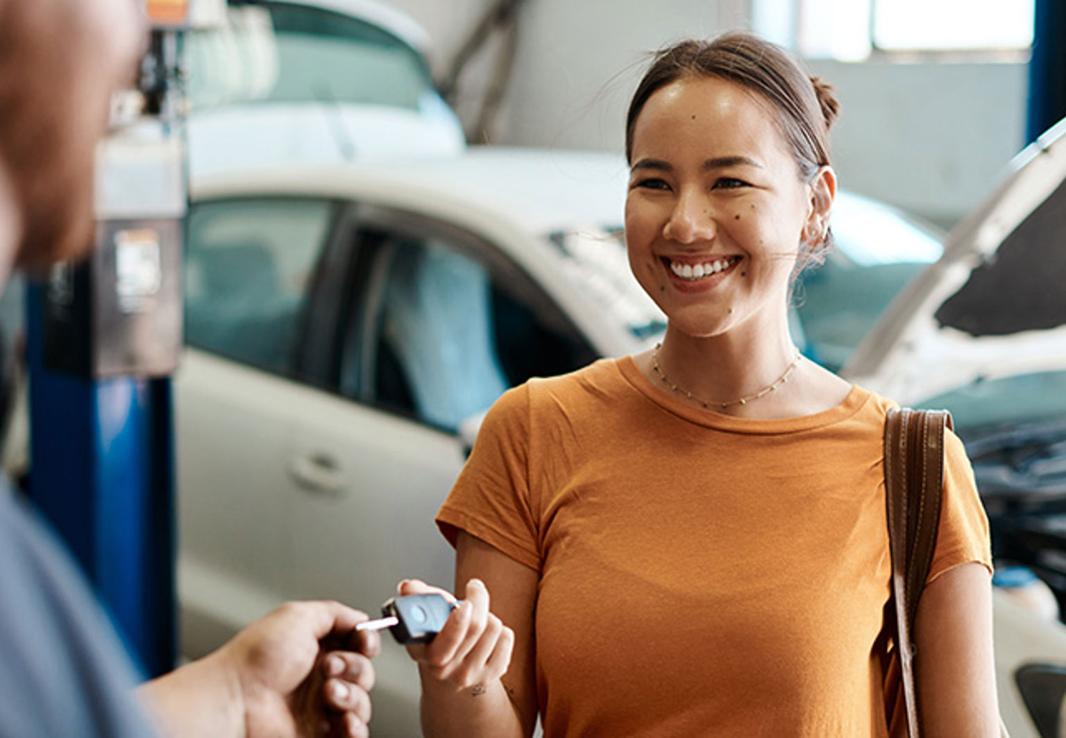 kvinna tar emot en bilnyckel på bilverkstad