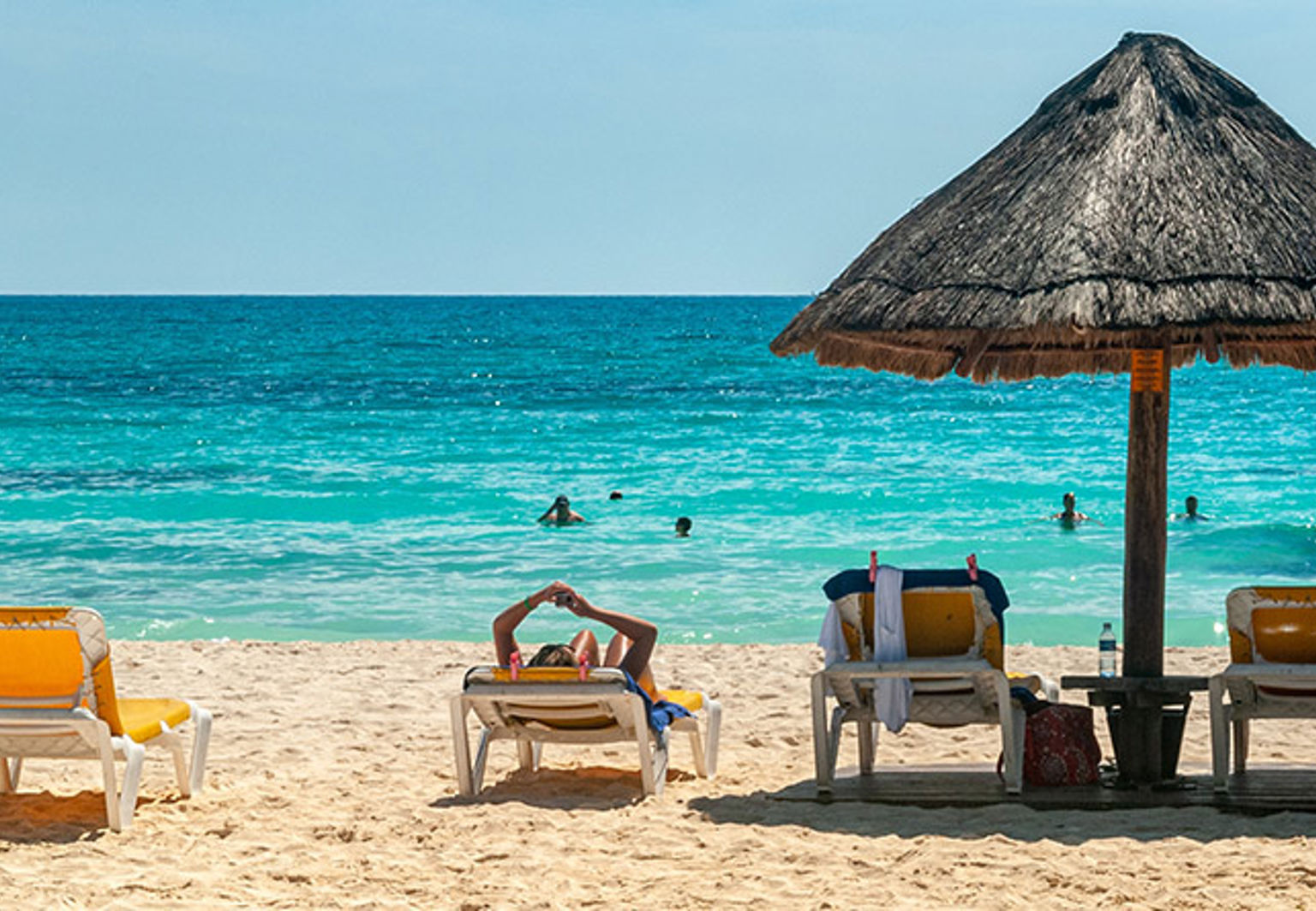 solstolar och ett parasoll på en strand