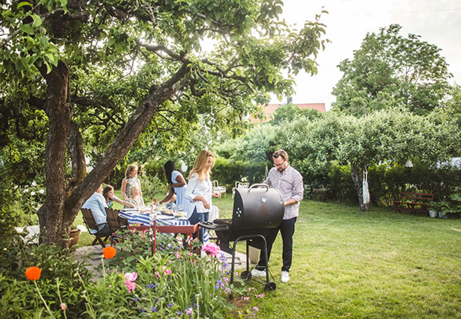 familj grillar i trädgården