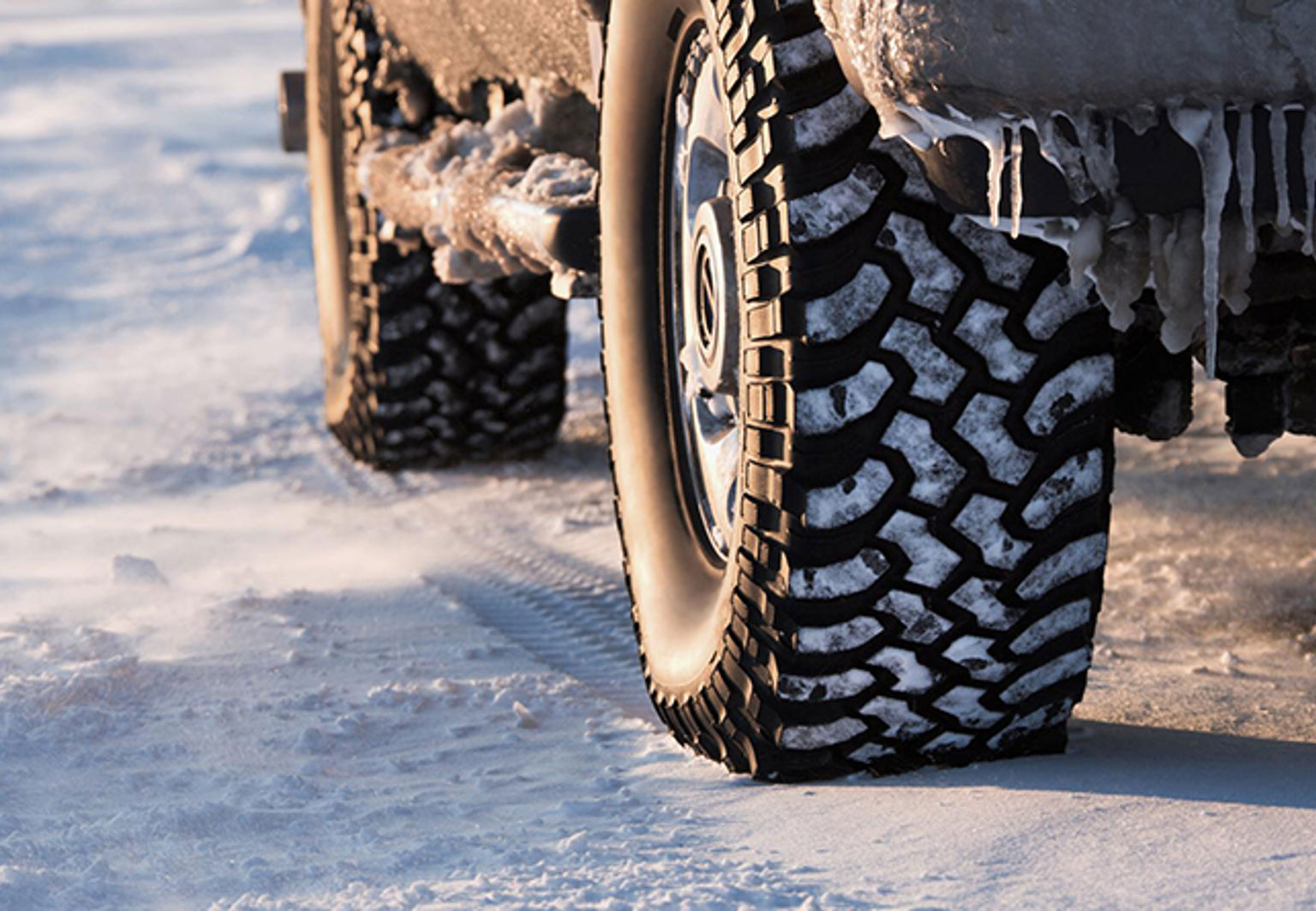 närbild på vinterdäck på vinterväg