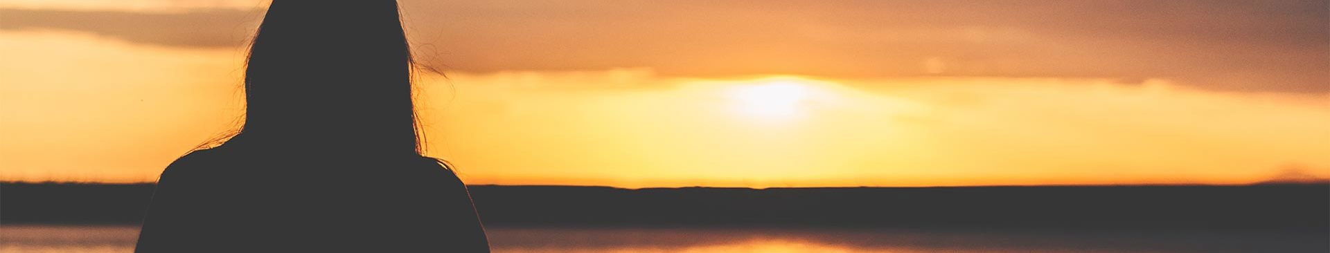 kvinna som ser en solnedgång