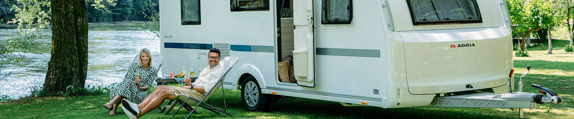 glatt par sitter utanför sin husvagn