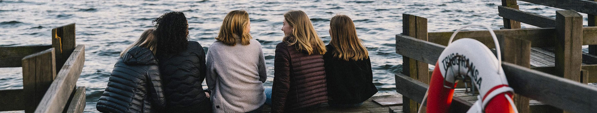 en grupp tjejer sitter på en brygga