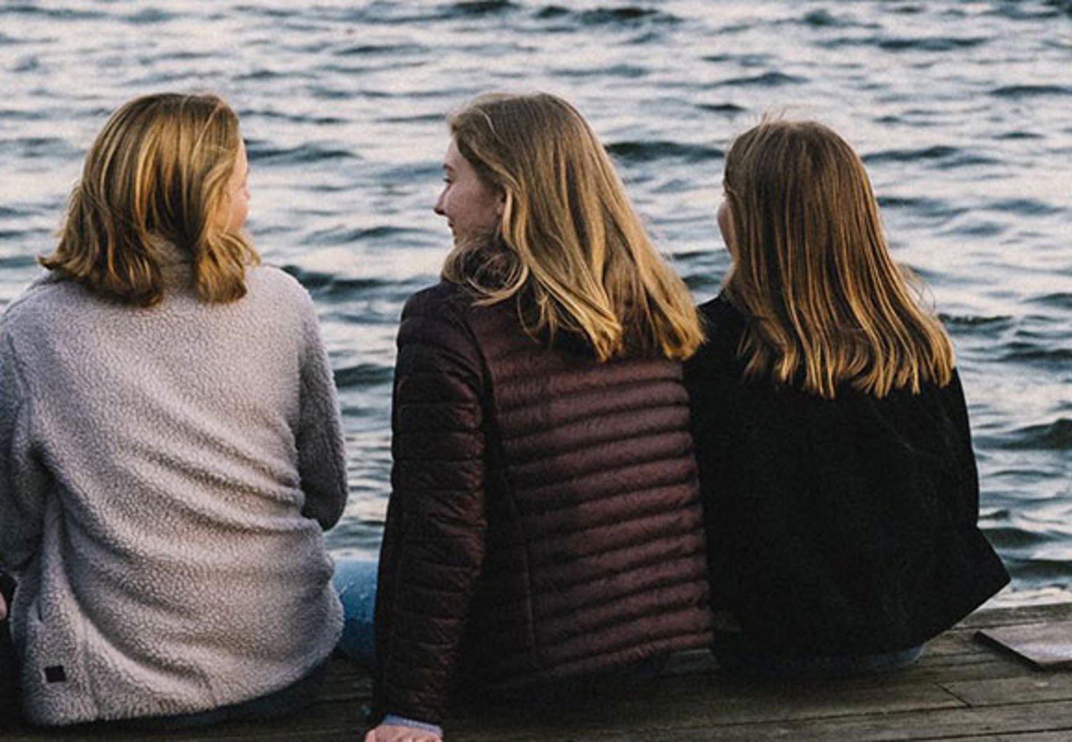 en grupp tjejer sitter på en brygga