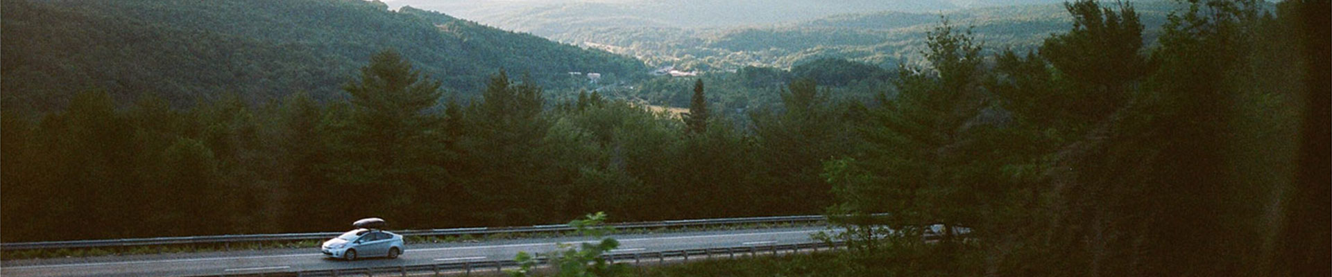 bil med takbox på vacker landsväg