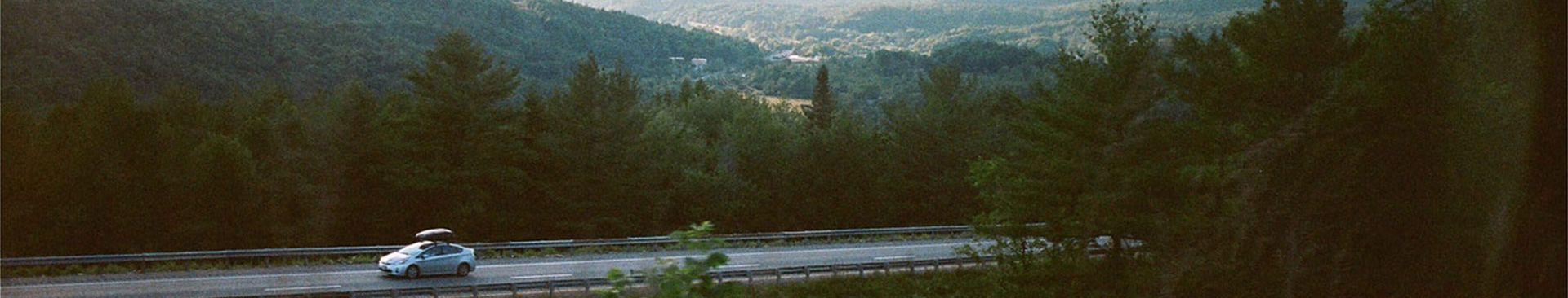 bil med takbox på vacker landsväg