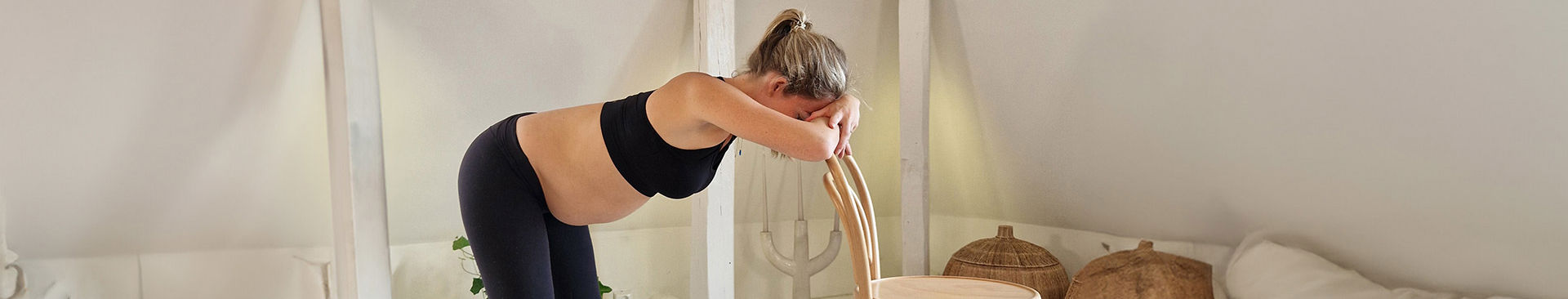 gravid kvinna lutar sig mot en stol