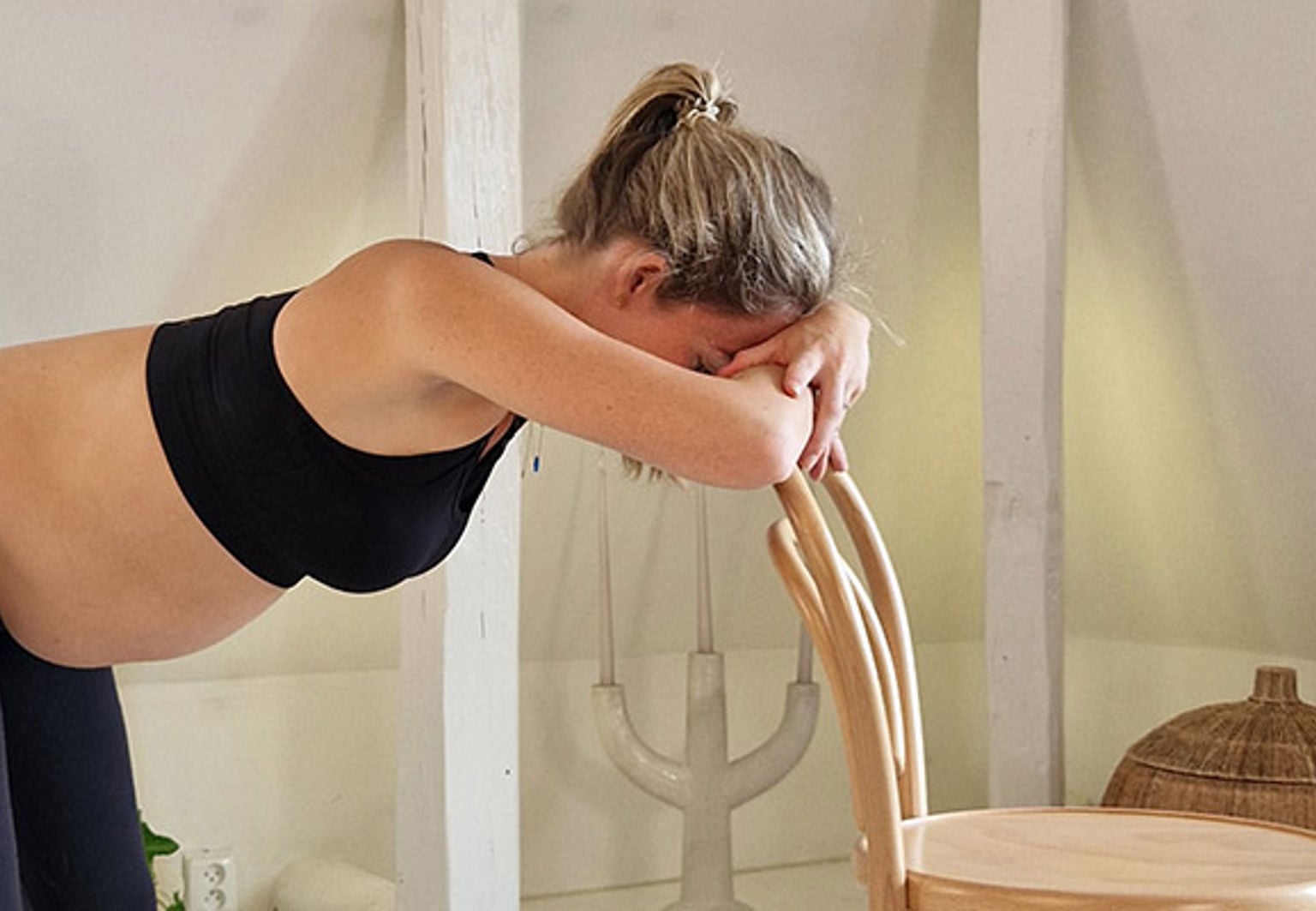 gravid kvinna lutar sig mot en stol