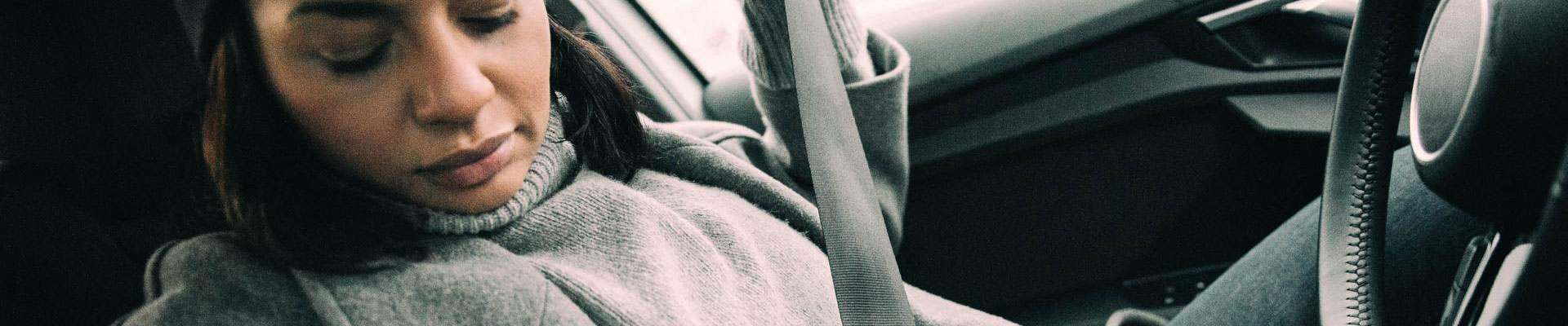 närbild kvinna som sätter på sig säkerhetsbälte