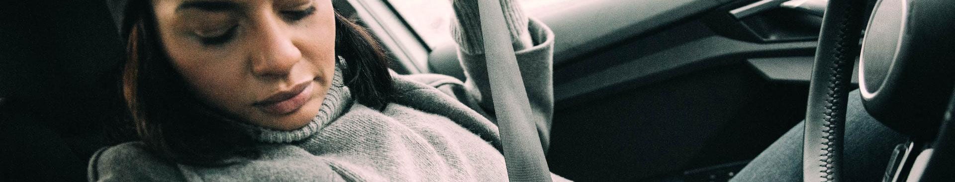 närbild kvinna som sätter på sig säkerhetsbälte