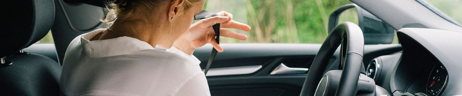 kvinna sätter på sig säkerhetsbälte i bil