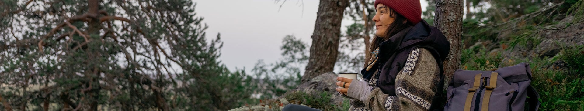 kvinna tar en fikapaus i skogen
