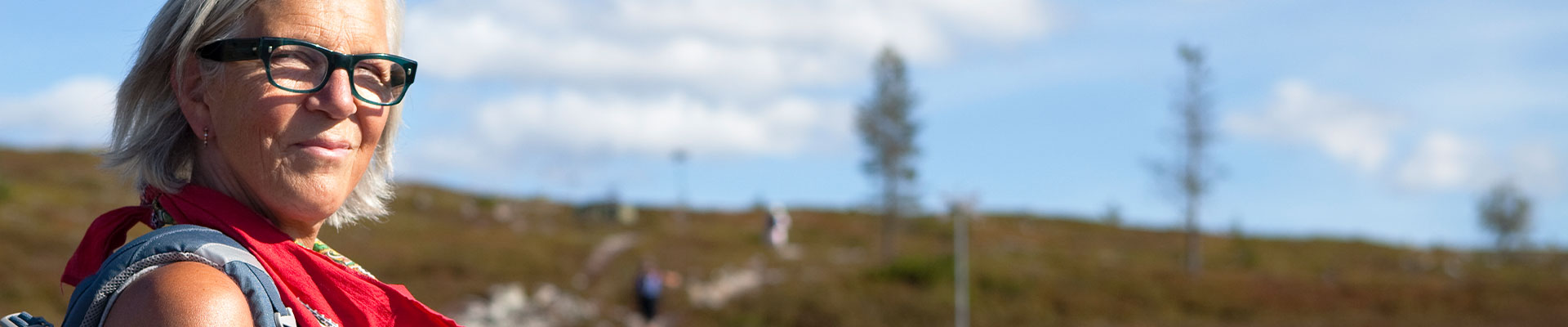 kvinna blickar ut över fjället på sommaren