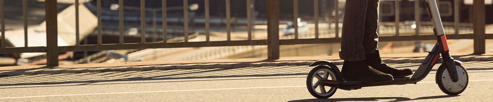 någon åker sparkcykel över en bro