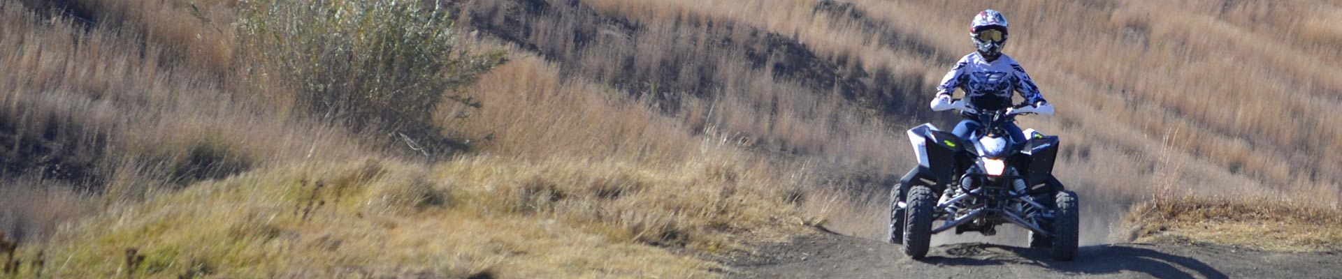 person som kör fyrhjuling ute i terräng