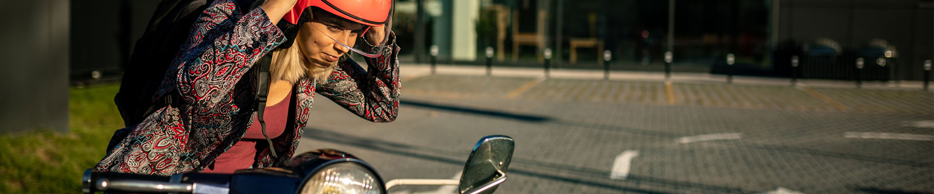 ung kvinna med röd hjälm vid sin moped