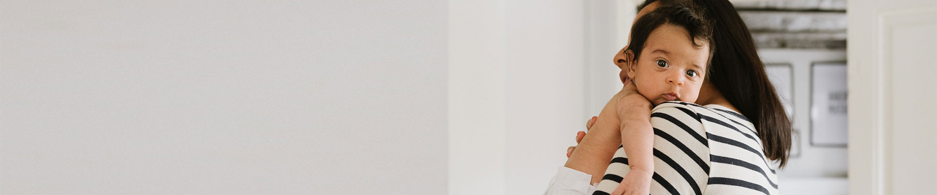 kvinna bär på sitt lilla barn