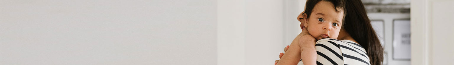 kvinna bär på sitt lilla barn