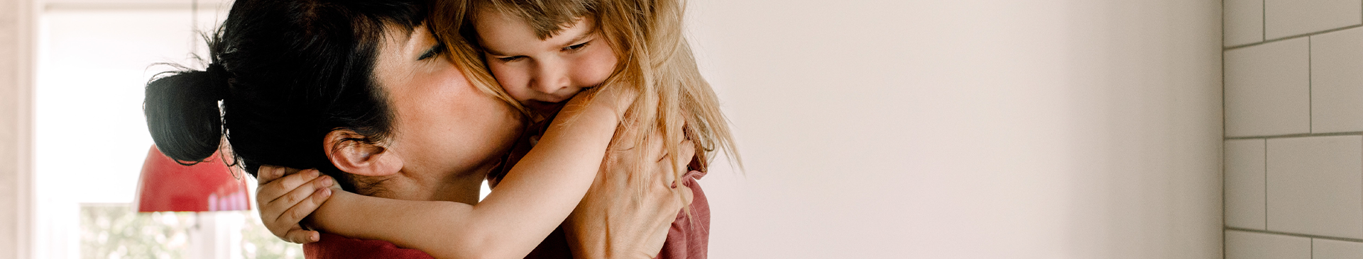 mamma ger sin dotter en puss på kinden