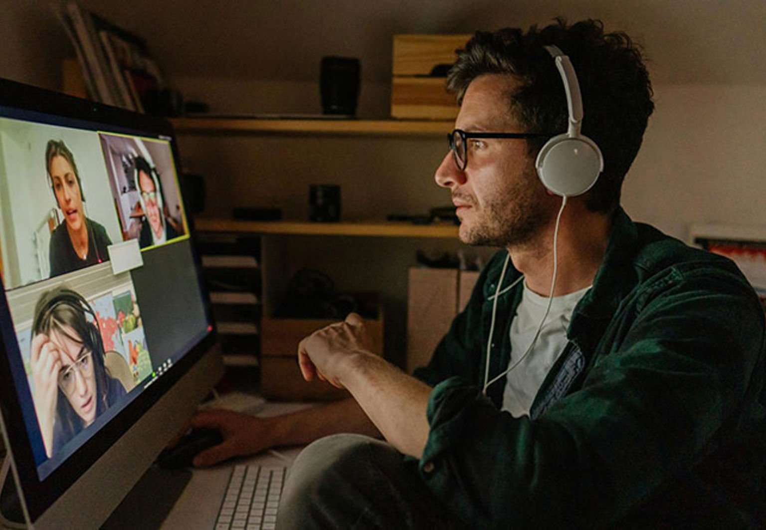 man med hörlurar i möte vid datorn