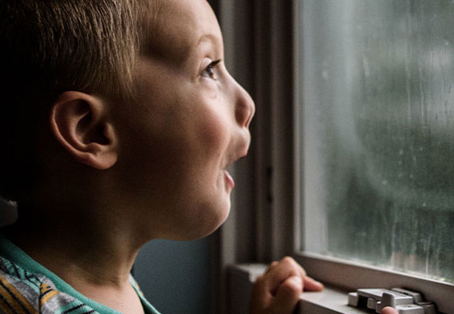 pojke tittar ut på stormen genom fönstret