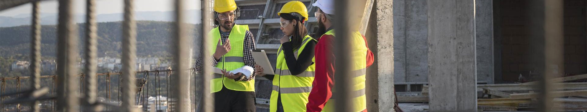 tre medarbetare på en byggarbetsplats
